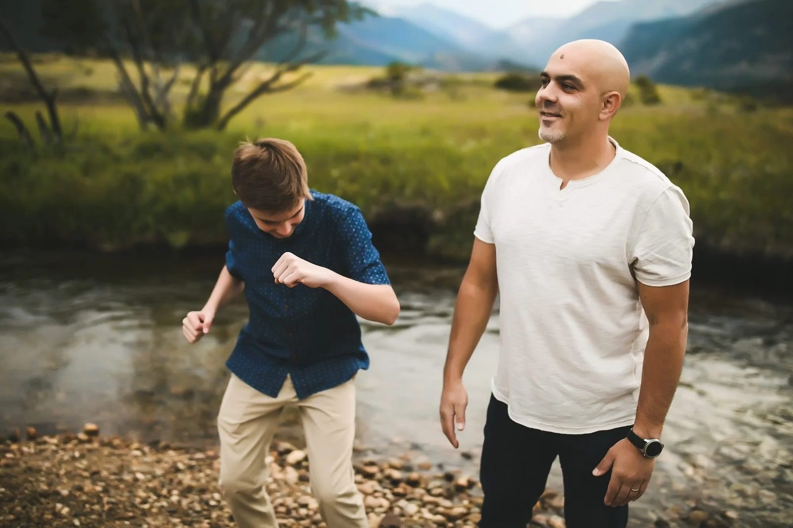 Jon Tetreault by a creek in the mountains with his son